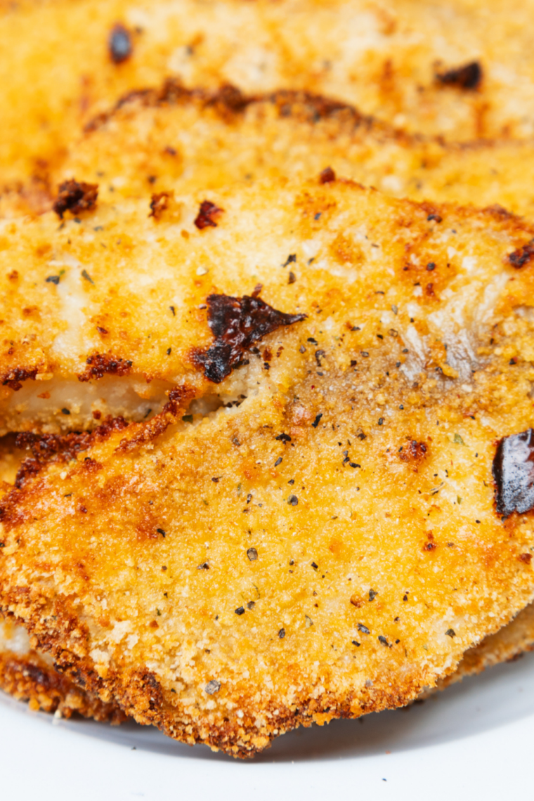 Close-up of tilapia fillets cooking on a Blackstone griddle with steam rising
