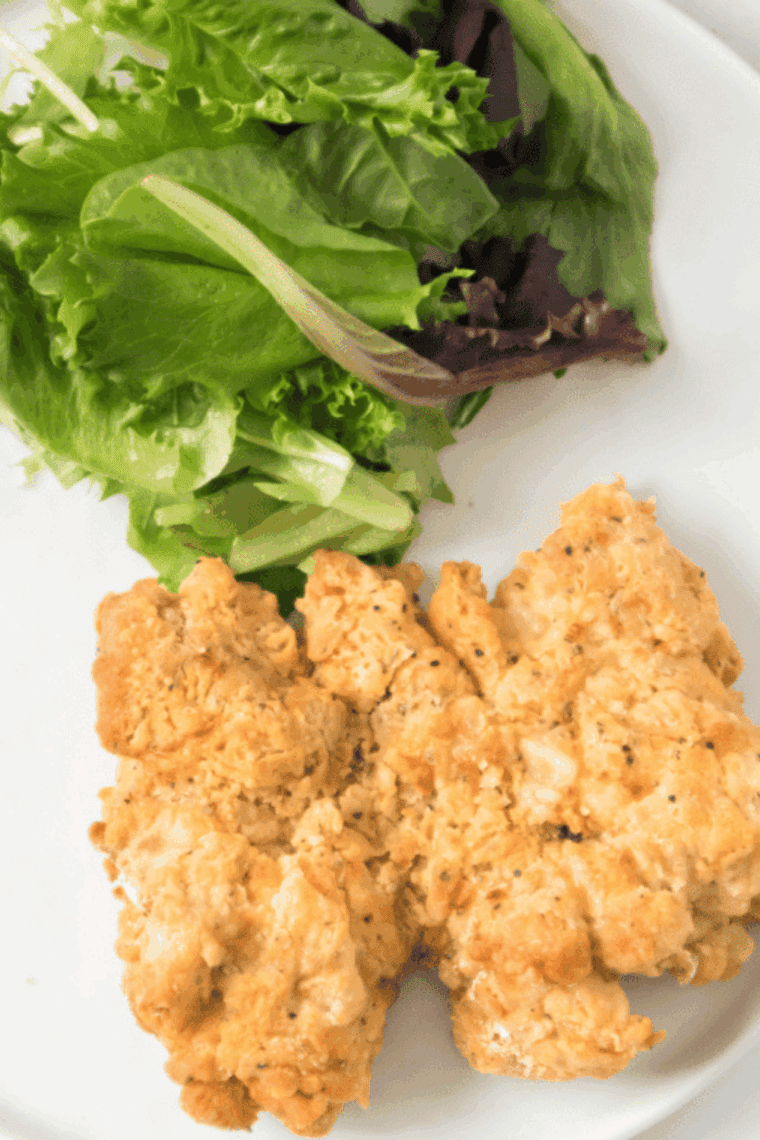 Plate of juicy Bob Evan's Fried Chicken on kitchen table.