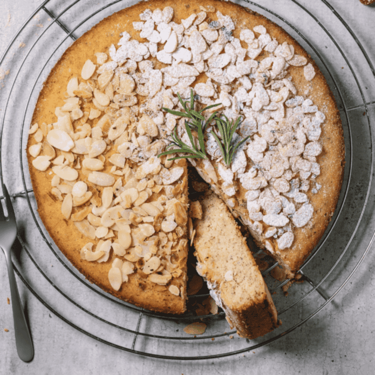 Easy air fryer almond cake with golden top, sliced and served on a plate.