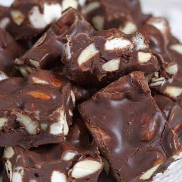 "A plate of rich, decadent Instant Pot Rocky Road Fudge with a variety of toppings including marshmallows, nuts, and chocolate chunks."