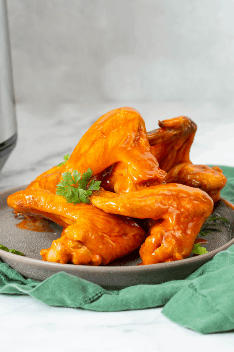 Golden-brown Ninja Foodi Buffalo Wings coated in spicy buffalo sauce