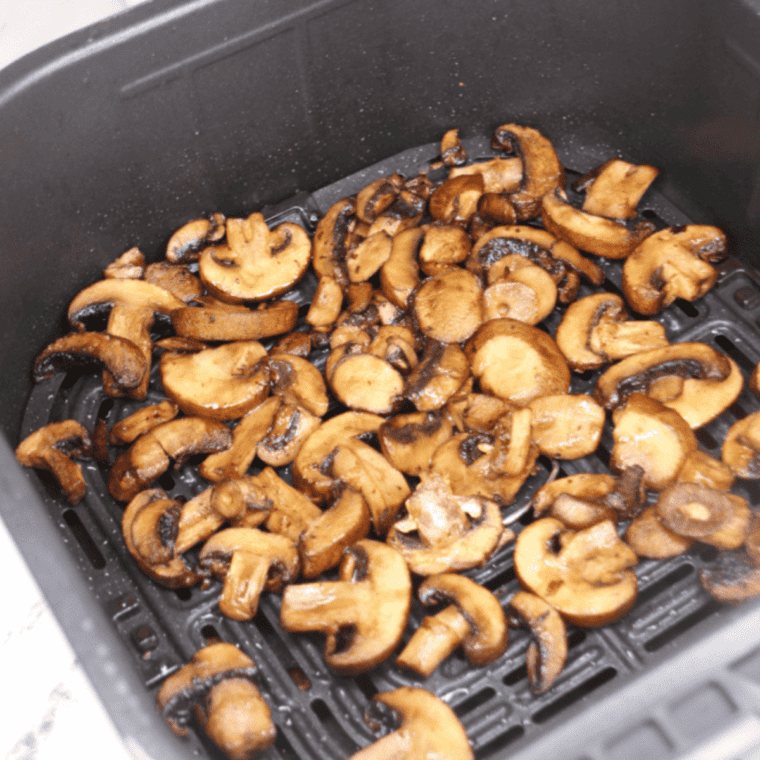 Cooked Steak and Ale Sauteed Mushrooms in the air fryer basket.