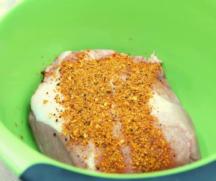 An uncooked and seasoned air fryer pork roast.