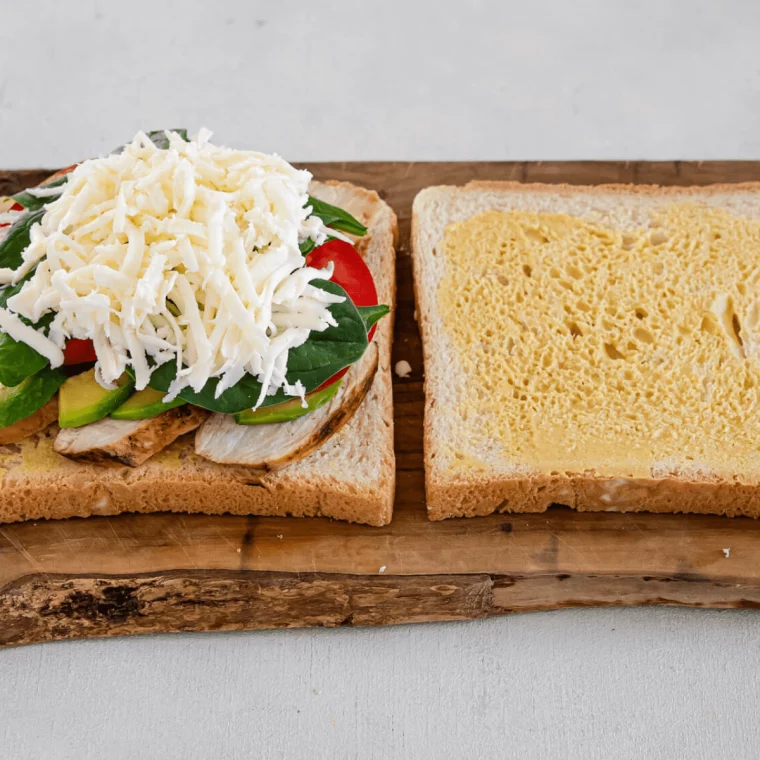 Assembling the sandwich, adding all of the toppings.