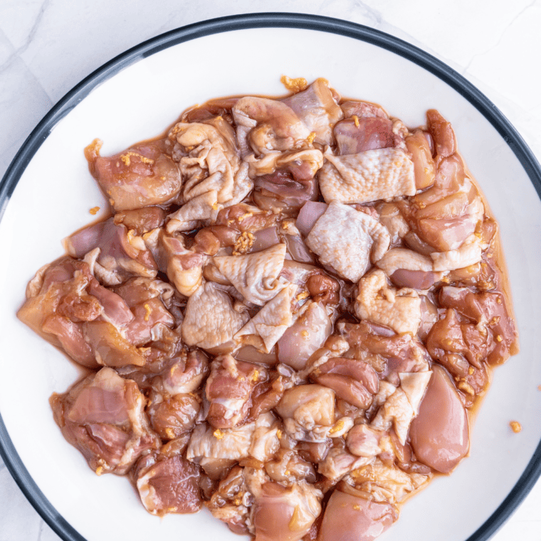 Chicken thigh pieces marinating in soy sauce, sake, garlic, ginger, and sesame oil for homemade air fryer karaage