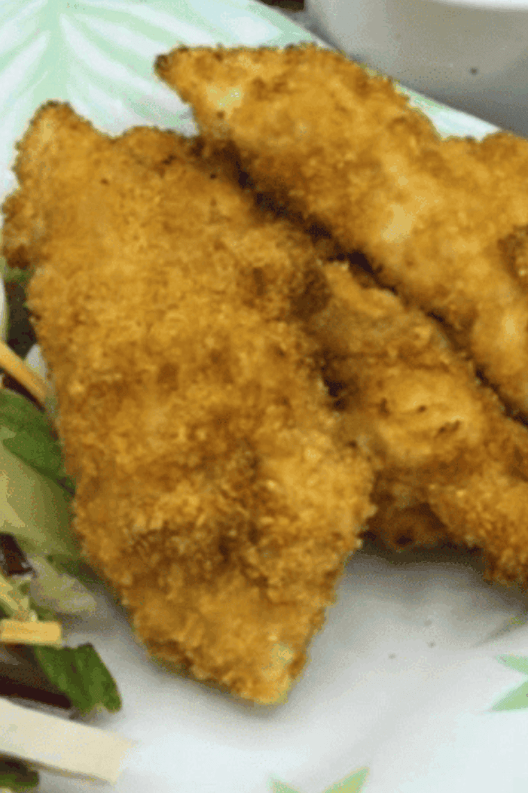 A close-up of a Bojangles copycat chicken tender being pulled apart to show the juicy interior.