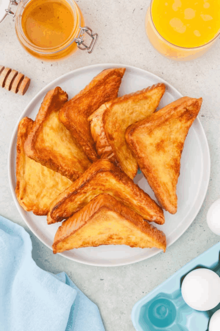 Golden air fryer honey toast with a buttery center and sweet honey drizzle on a plate.