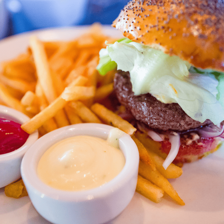 Juicy air fryer lamb burgers on a plate with melted cheese, lettuce, and tomato, ready to serve.