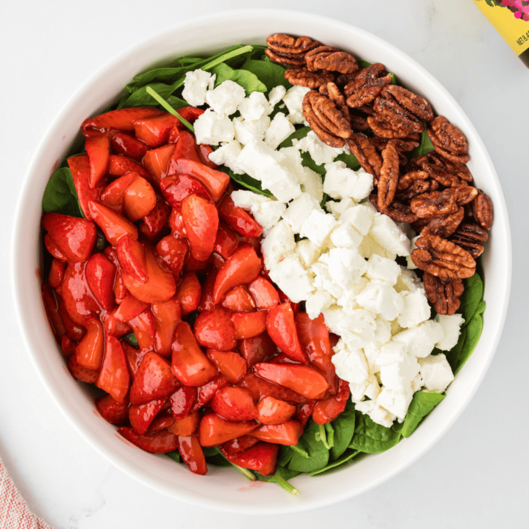 Drizzle balsamic glaze over the Air Fryer Spinach Strawberry Salad and toss gently to coat the ingredients evenly with the dressing.