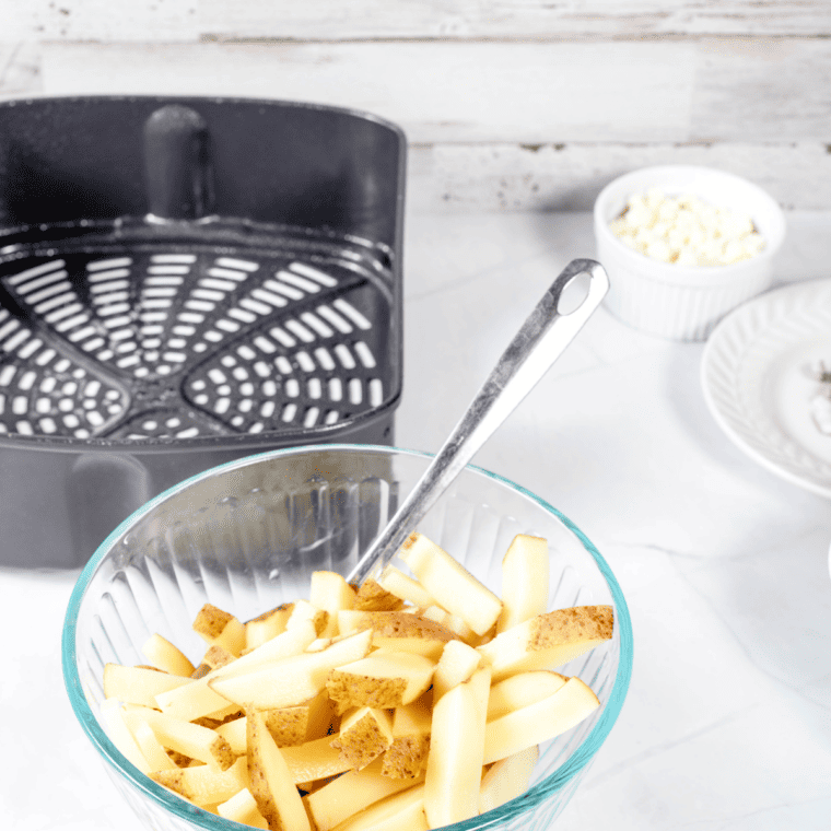 Fresh potatoes being cut into fry shapes for Air Fryer Truffle Fries.