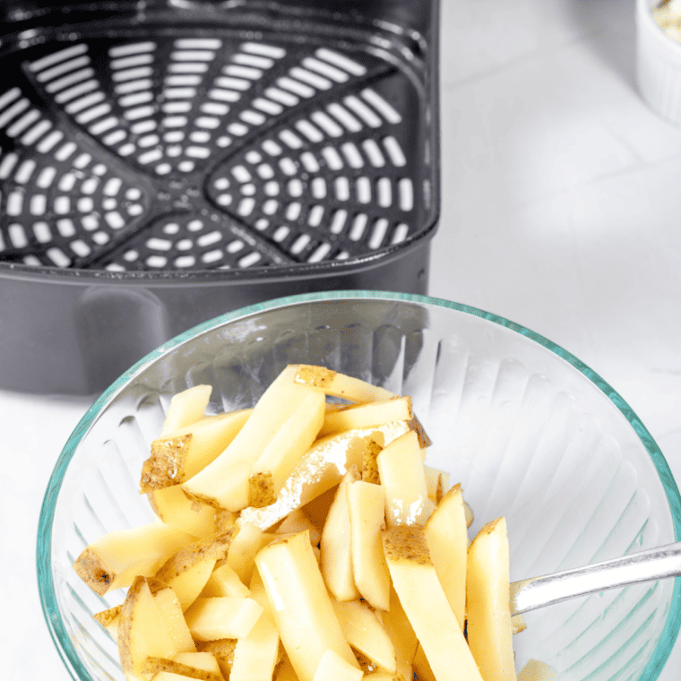 Potatoes soaking in water to remove excess starch before air frying.
