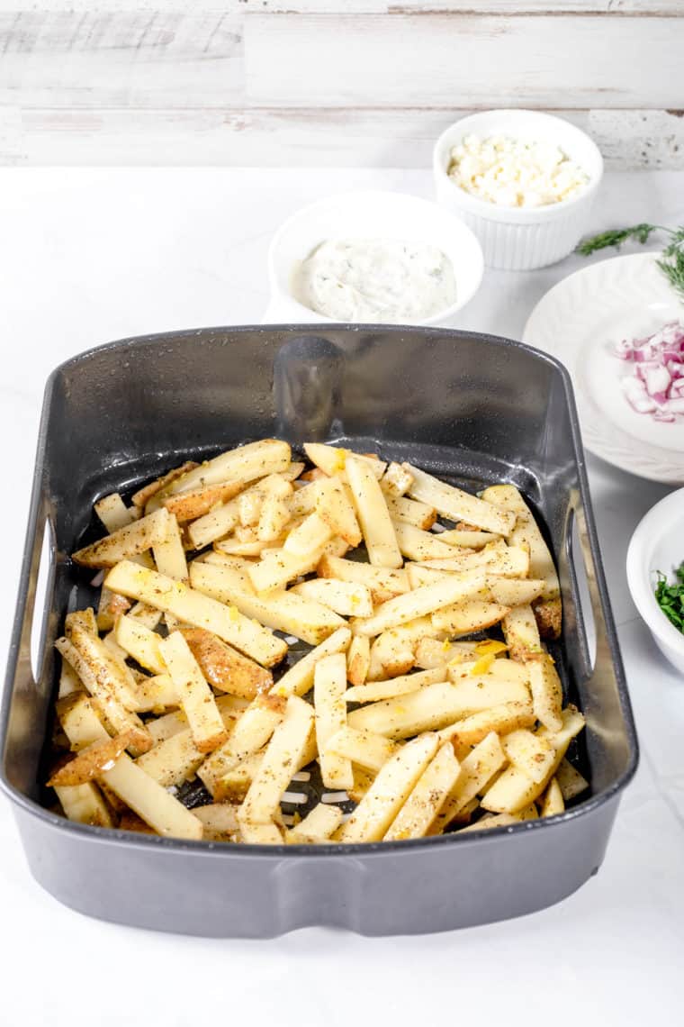 Arranging the seasoned fries in a single layer in the air fryer basket.