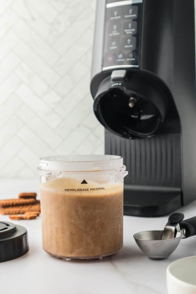 Pouring the gingerbread ice cream base into a Ninja Creami pint container before freezing