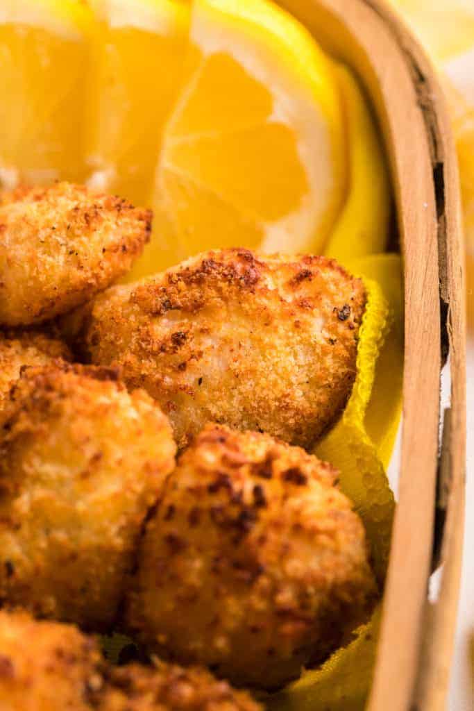 catfish nuggets and lemon slices in wooden container