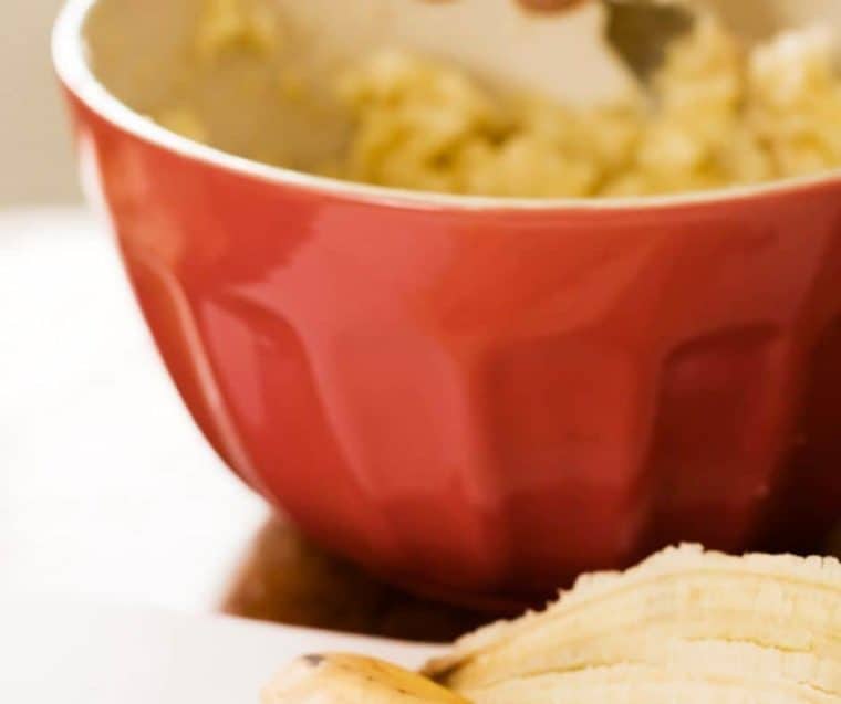 banana peels next to red mixing bowl