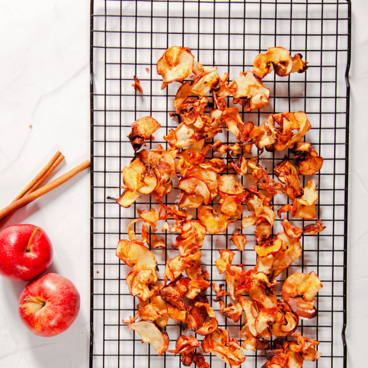 Close-up of golden, crispy homemade apple chips dusted with cinnamon