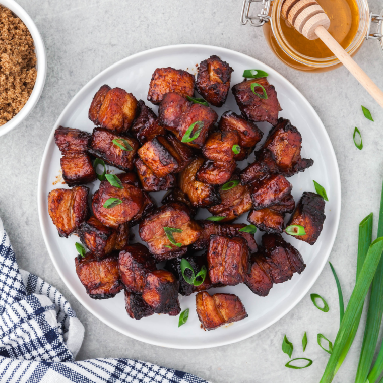 Close-up of sticky honey glazed crispy pork belly bites showing caramelized edges and glossy sauce