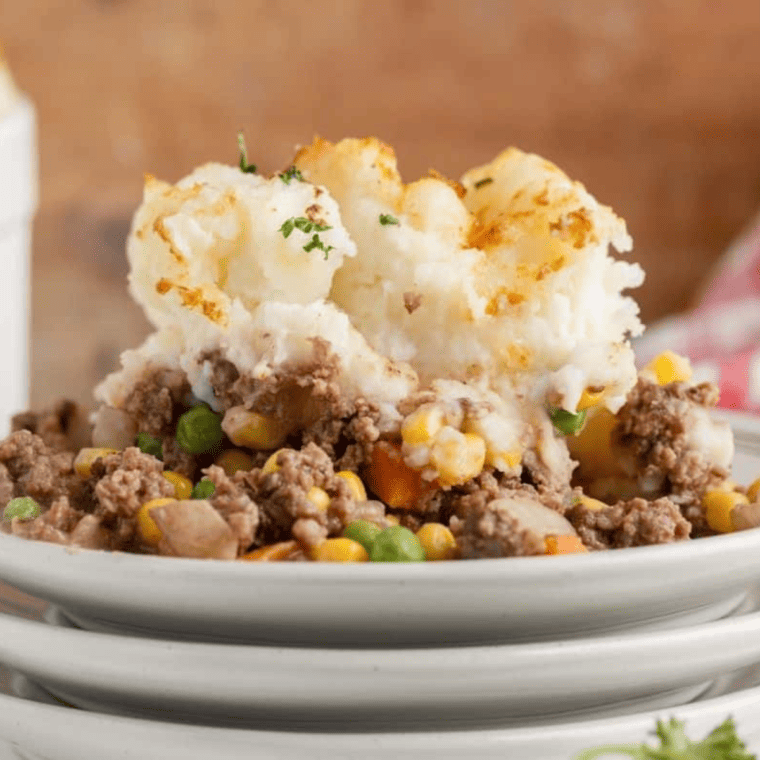 Golden, crispy-topped Shepherd’s Pie in an air fryer basket, filled with seasoned meat and mashed potatoes.