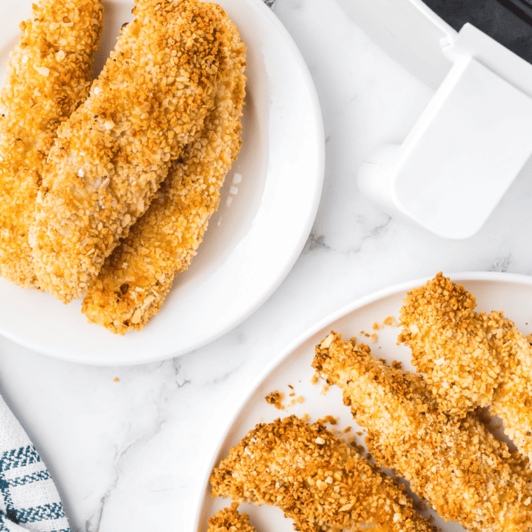 Golden, crispy homemade Whataburger-style chicken strips served with dipping sauce on a plate.