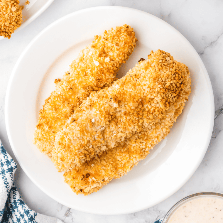 Golden, crispy homemade Whataburger-style chicken strips served on a plate with dipping sauce.