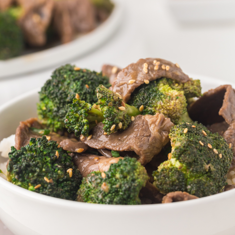 Blackstone beef and broccoli sizzling on a flat top griddle with tender steak slices and fresh broccoli in savory sauce.