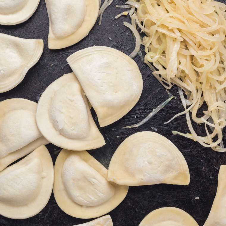 Frozen pierogies cooking on a Blackstone griddle, turning golden and crispy