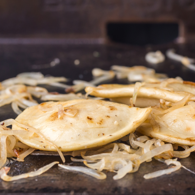 Crispy Blackstone pierogies tossed with caramelized onions and garlic