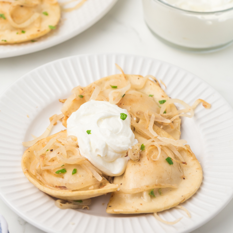 Easy Blackstone pierogies topped with caramelized onions and fresh herbs