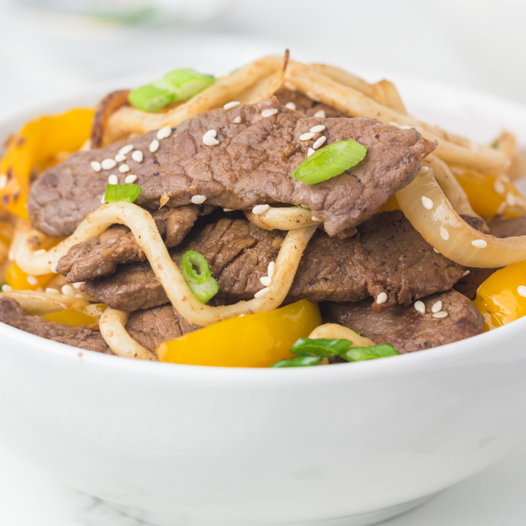 Blackstone Steak Udon with seared steak strips, udon noodles, and vegetables piled on the griddle