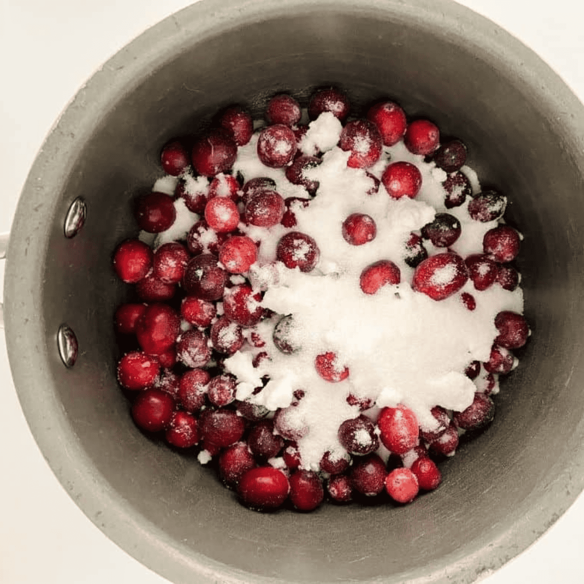 Simmering fresh cranberries with sugar and lemon juice in a saucepan until thick and jammy.