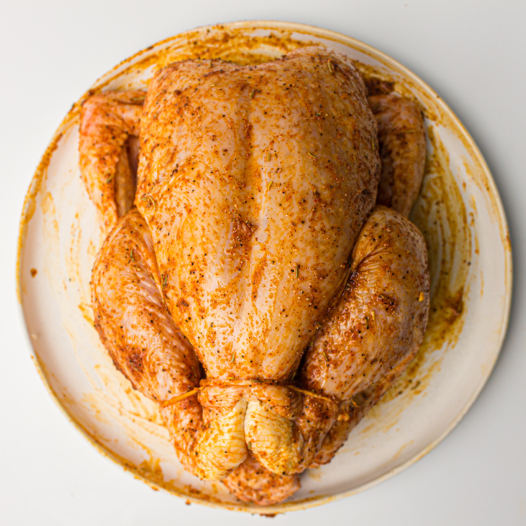 Seasoned chicken roasting in a pan until golden and cooked to an internal temperature of 165°F, ensuring juicy perfection.