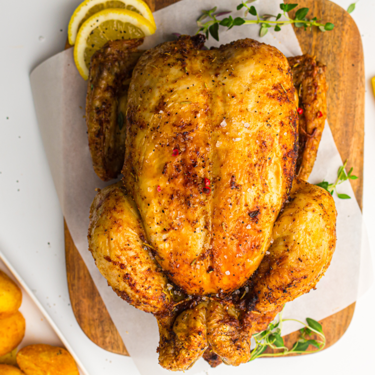Perfectly seasoned homemade Costco rotisserie chicken on a serving platter with crispy golden skin.
