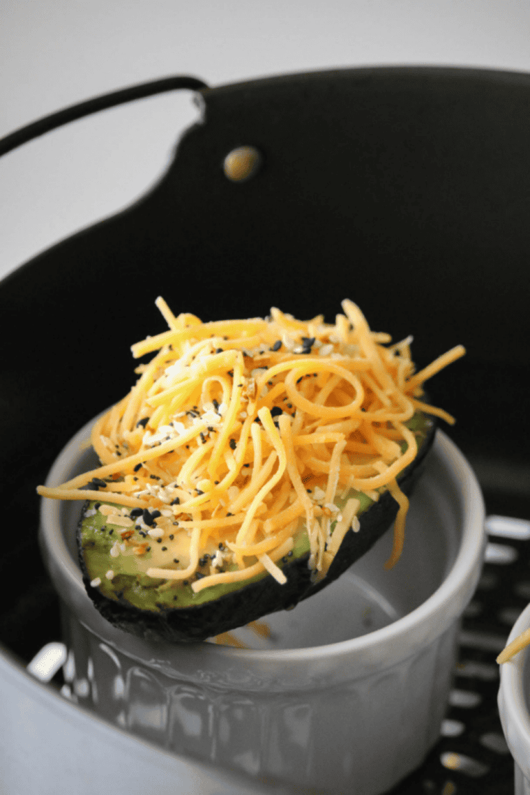 air fryer stuffed avocado with melted cheese and creamy filling on plate