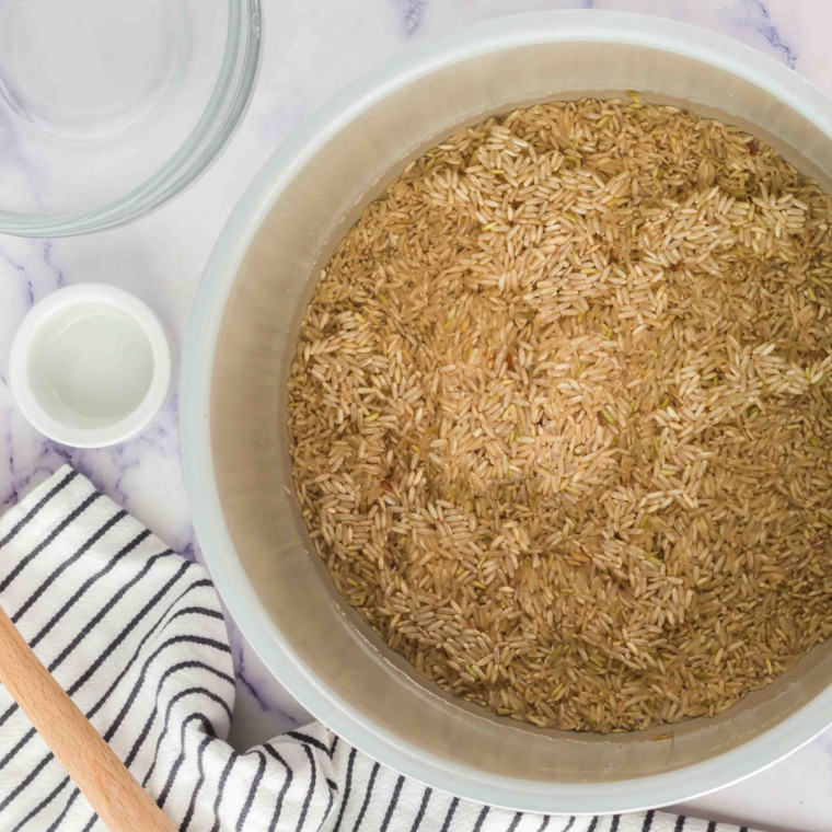 Rinsing brown rice under cold water to remove excess starch.