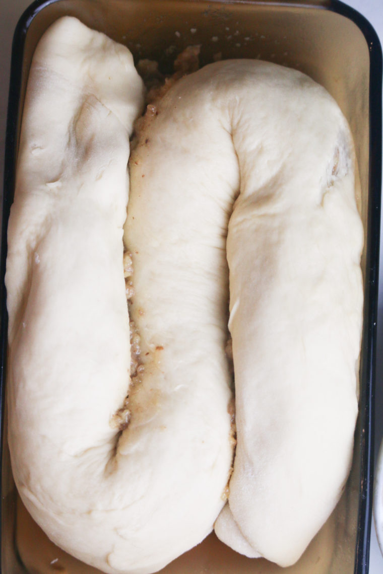 Placing the uncooked bread to rise.
