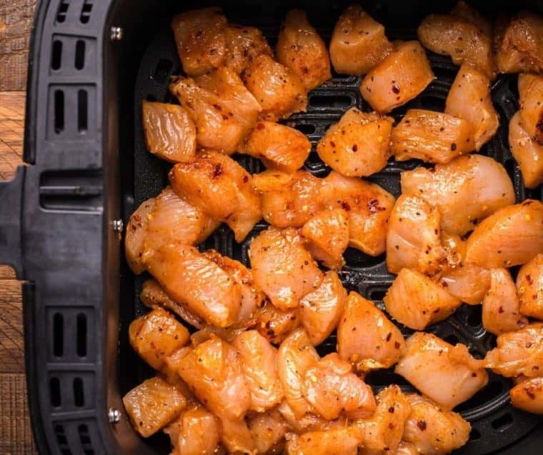 Uncooked chicken bites in air fryer.