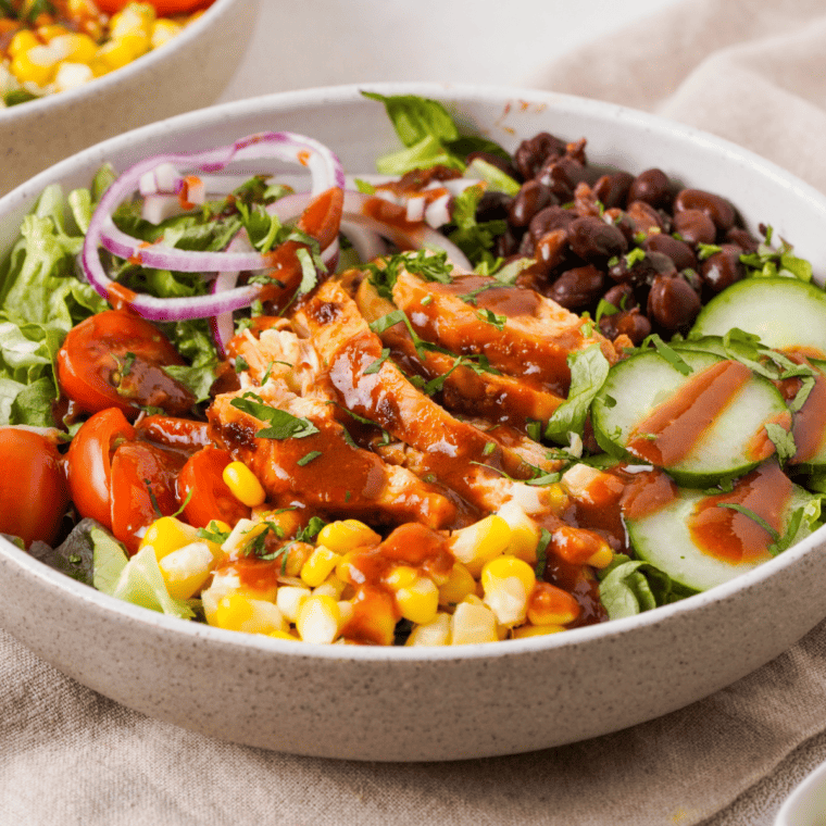 "Colorful bowl of Air Fryer BBQ Chicken Salad topped with barbecue sauce"