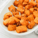 Air fryer frozen butternut squash cubes with caramelized golden edges in a white serving bowl