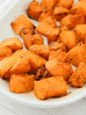 Air fryer frozen butternut squash cubes with caramelized golden edges in a white serving bowl