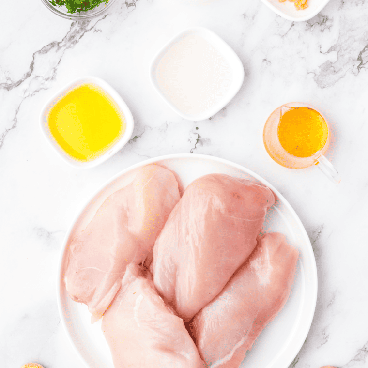 Ingredients needed for air fryer chicken bites on a countertop, marble.