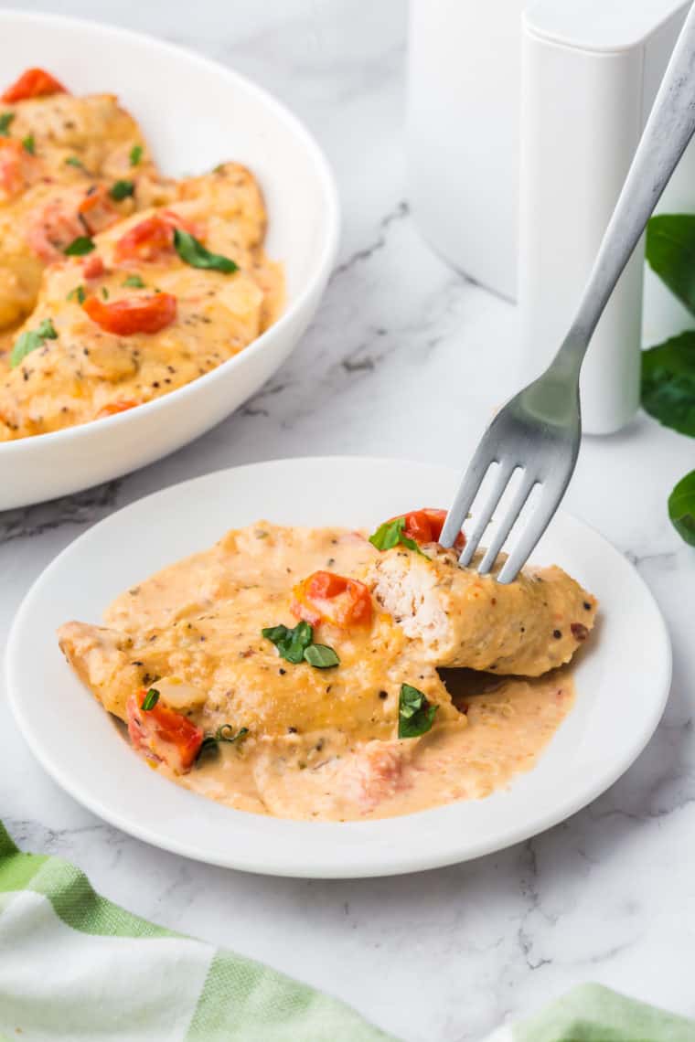 Air Fryer Marry Me Chicken served with creamy sauce, garnished with fresh herbs, on a white plate.