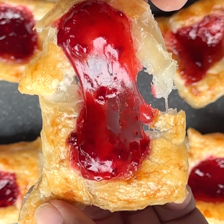 Golden, flaky Air Fryer Raspberry Danish with raspberry filling and a sweet glaze, served on a plate.