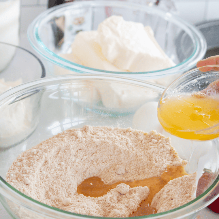 Pressing graham cracker crust evenly into a lined pan using a spoon or glass before freezing.