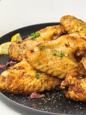 Plate of Ninja Crispi frozen chicken wings, cooked crispy and tossed in buffalo sauce, served on a black plate