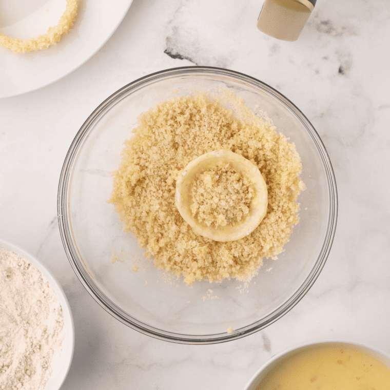 Coating onion rings in flour, buttermilk-beer-egg mixture, and Panko breadcrumbs for Air Fryer Beer Battered Onion Rings.