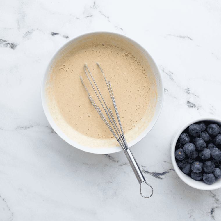 Blueberry pancake batter mixed gently with spatula until just combined