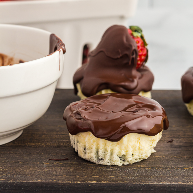 Freshly topped mini cheesecakes with chocolate-dipped strawberries before chilling