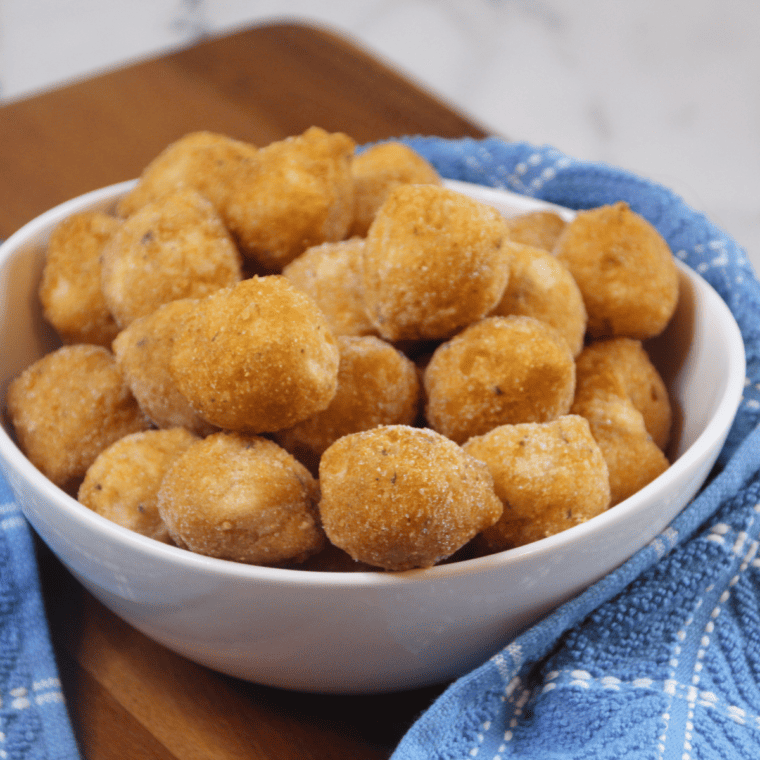 Bag of Savannah Classics frozen hush puppies and cooking spray laid out on a kitchen counter