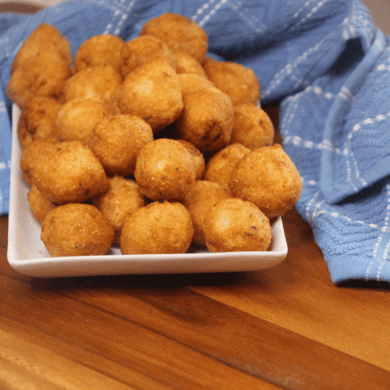 Air fryer frozen hush puppies piled in a white serving bowl