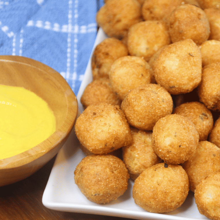 Bowl of hot honey mayo dipping sauce next to air fryer hush puppies